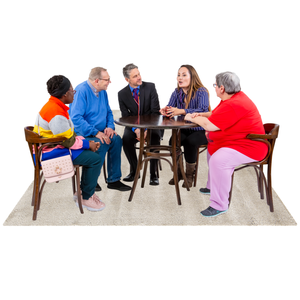 A group of five people meet at a small table