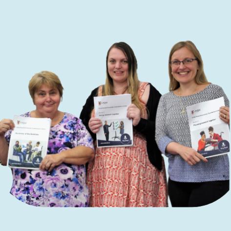 Three women holding GeneEQUAL resource booklets.