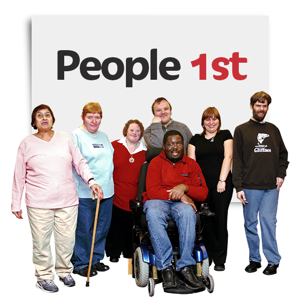 A group of people sitting and standing in front of a panel reading "people first"